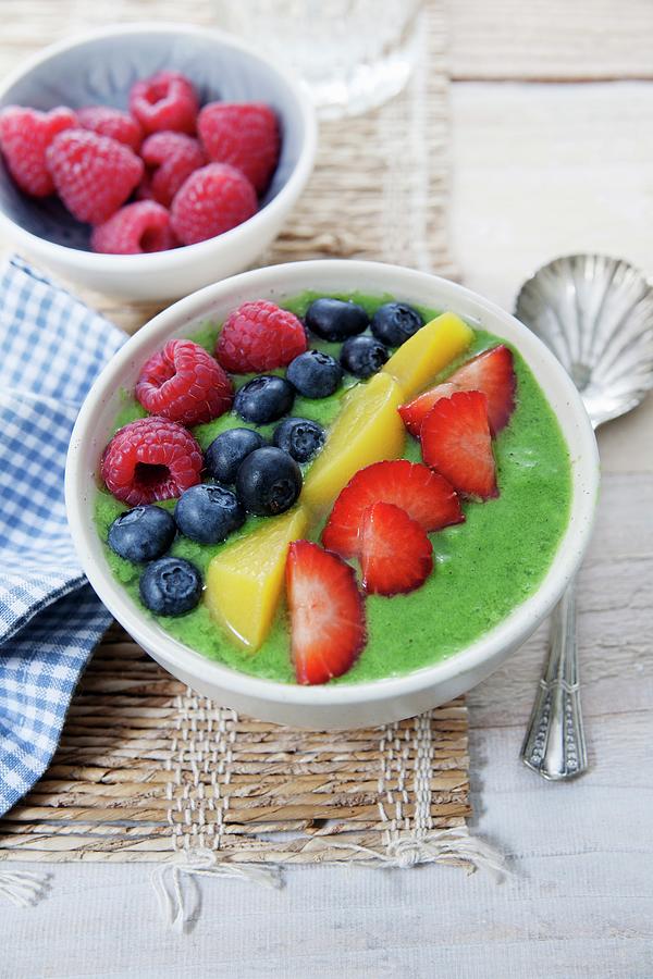 A Smoothie Bowl With Kiwi, Mango, Spirulina, Raspberries, Blueberries And Strawberries Photograph by Victoria Firmston