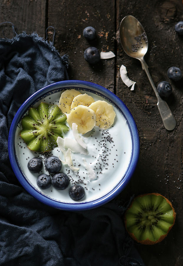 A Smoothie Bowl With Soy Yoghurt, Fruit, Poppy Seeds And Coconut Flakes Photograph by Stacy Grant