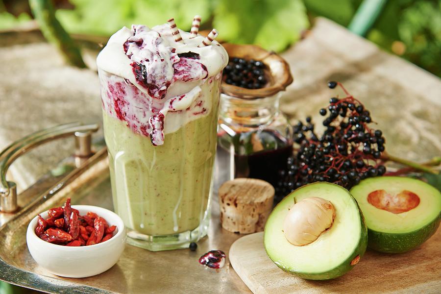 A Smoothie With Avocado, Chili And Elderberry Frosting On A Garden Table Photograph by Foto4food