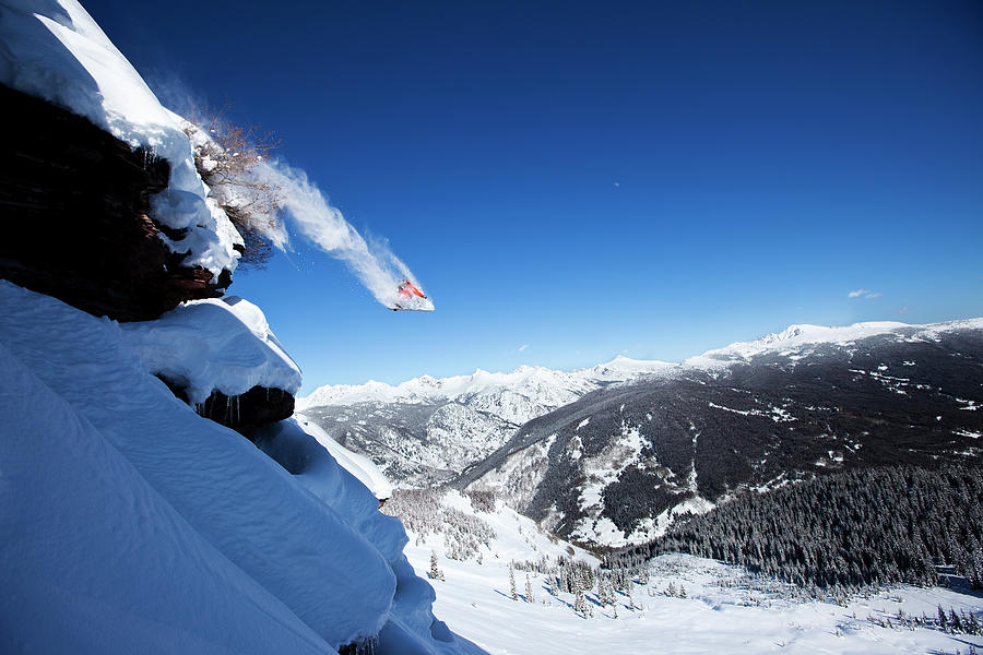 A Snowboarder Jumps Off A Cliff Into Photograph by Patrick Orton A Snowboarder Jumps Off A Cliff Into Photograph by Patrick Orton
