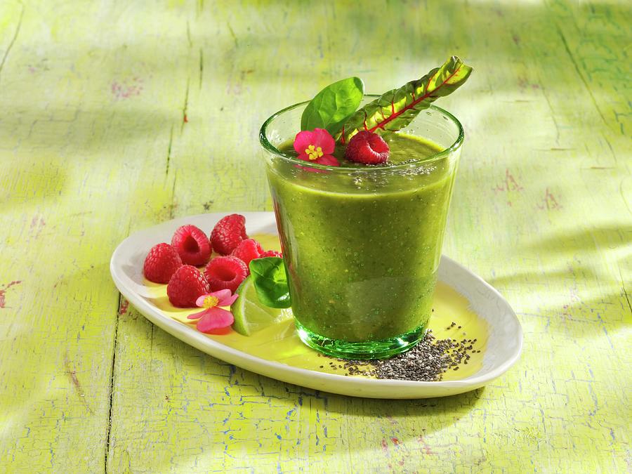 A Spinach And Banana Smoothie With Raspberries, Chia Seeds And Acai Powder Photograph by Karl Newedel