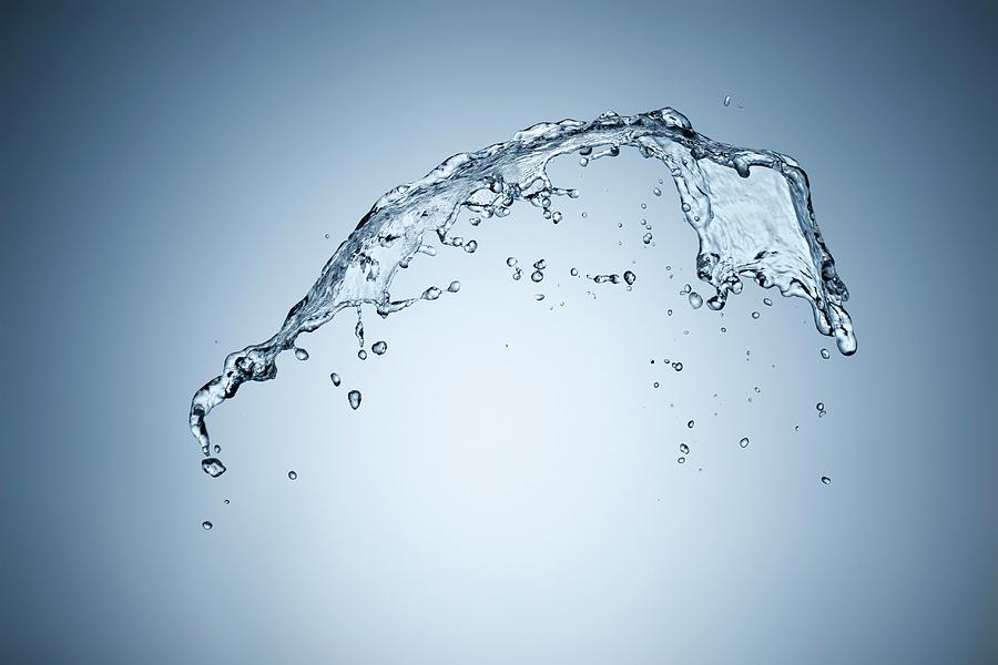 A Splash Of Water Against A Grey Background Photograph by Krger & Gross