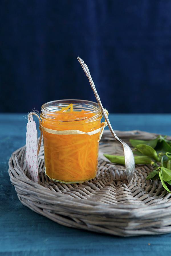 A Spoon Leaning Against A Jar Of Orange Marmalade On A Wicker Tray Photograph by Aniko Takacs
