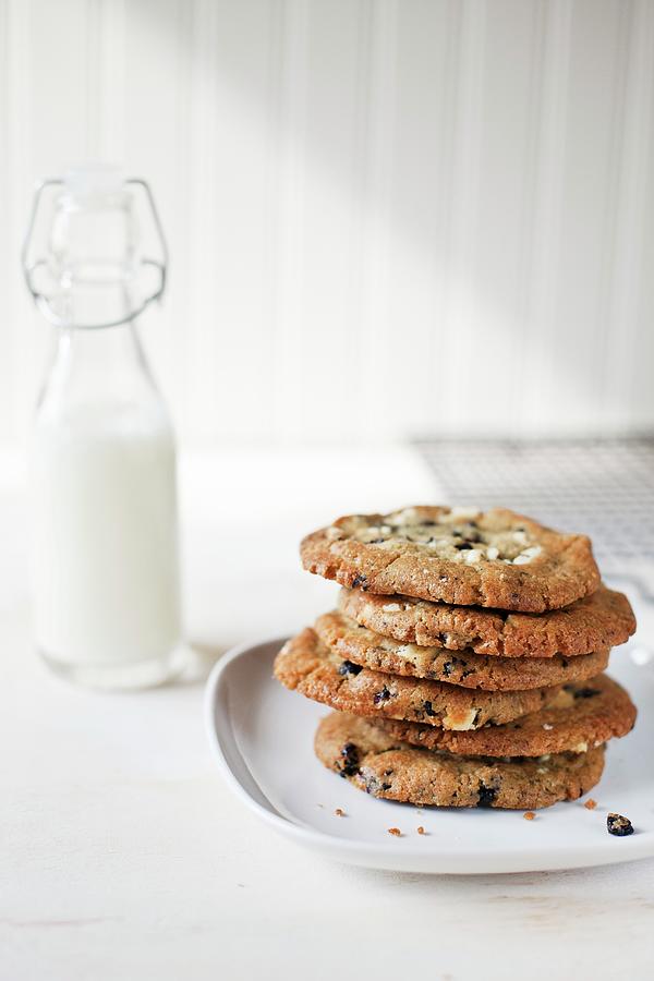 A Stack Of Blueberry Cookies On A White Plate; Bottle Of Milk ...