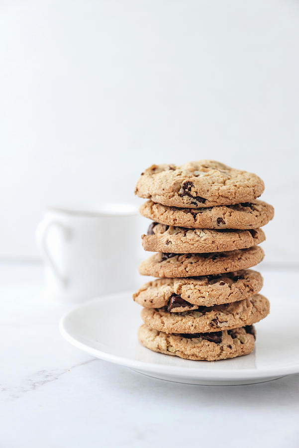 A Stack Of Chocolate Chip Cookies With A Cup Of Milk In The Background Photograph by Max D. Photography