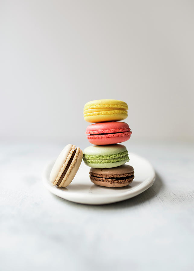 A Stack Of Colourful Macarons Against A White Background Photograph by Lisa Rees