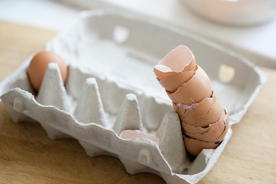 A Stack Of Eggshells In An Egg Carton Photograph by Edyta Girgiel