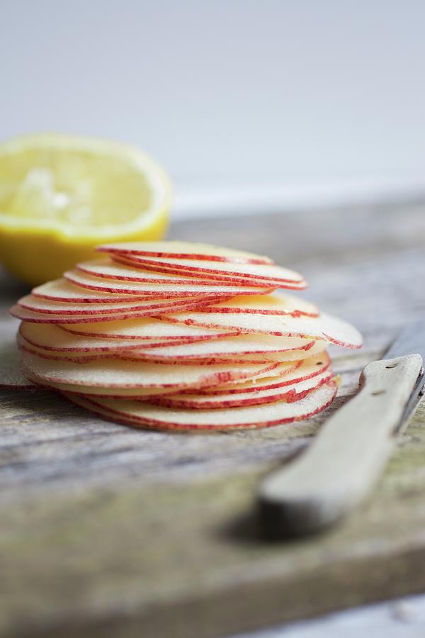 A Stack Of Fine Apple Slices With A Knife And A Lemon Photograph by Tina Engel