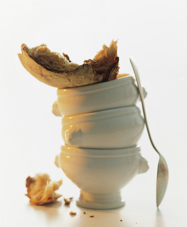 A Stack Of Individual Soup Tureens With A Spoon And Chunks Of Crusty