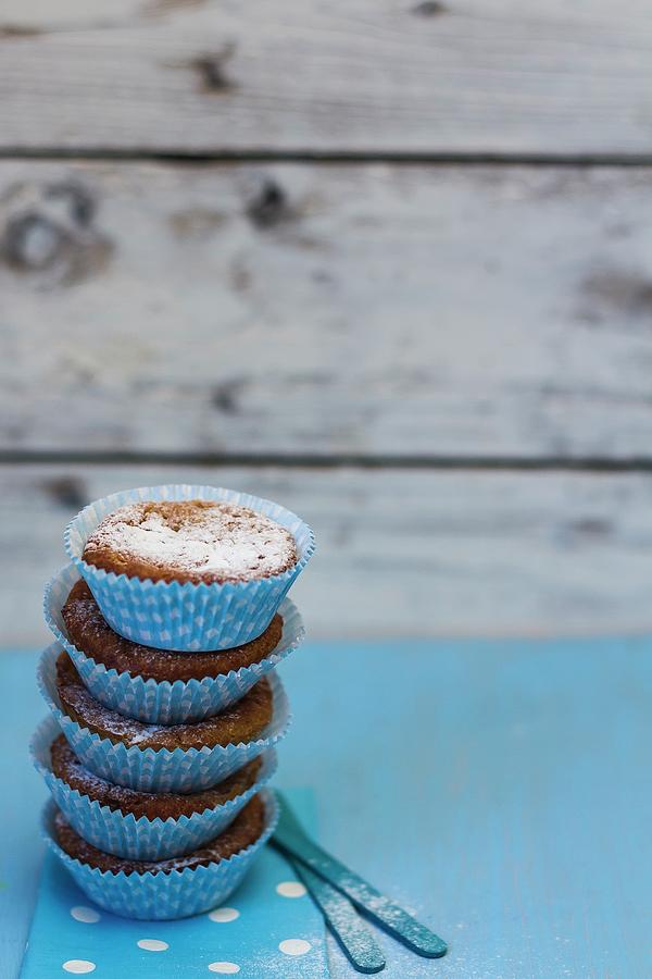 A Stack Of Muffins With Icing Sugar In Blue Paper Cases Photograph by Adel Bekefi