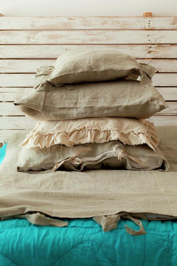 A Stack Of Pillows With Linen Covers On A Bed With A Turquoise Quilt And A Rustic Wooden Headboard Photograph by Studio Lipov