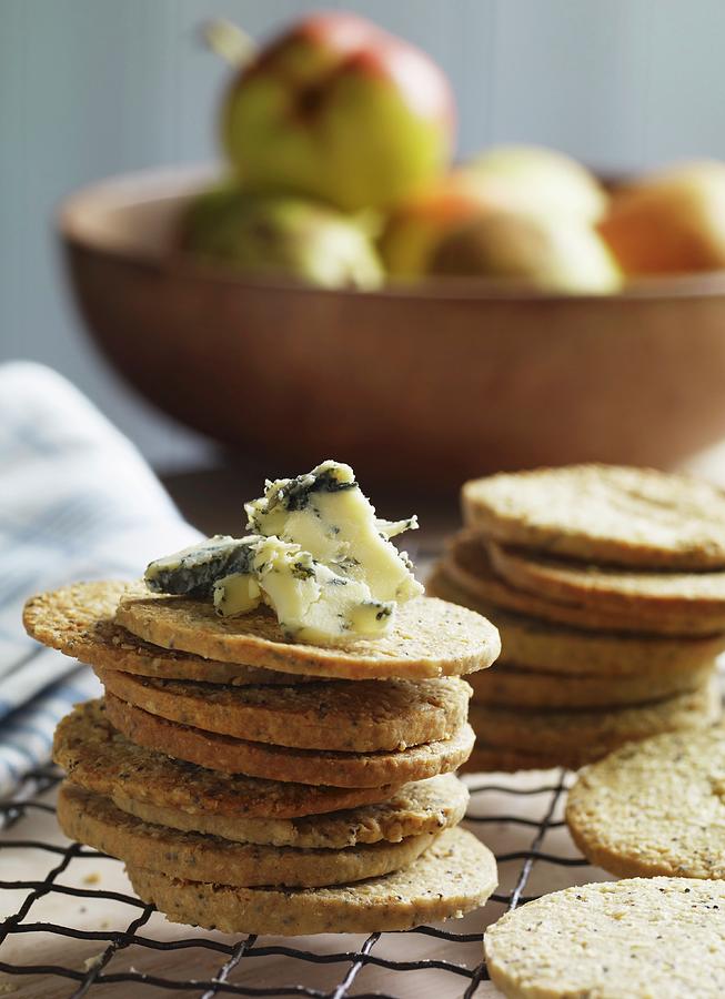 A Stack Of Poppy Seed And Oat Biscuits With Stilton With A Bowl Of Pears In The Background Photograph by Atkinson / Sue Dr.