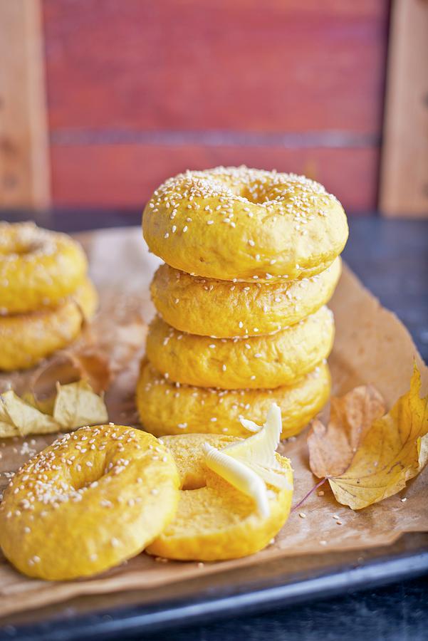 A Stack Of Pumpkin Bagels With Autumnal Leaves On A Baking Tray Photograph by Dorota Indycka