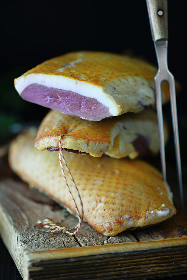 A Stack Of Smoked Magret Canard duck Breasts On A Wooden Board With A Metal Fork Photograph by Jamie Watson