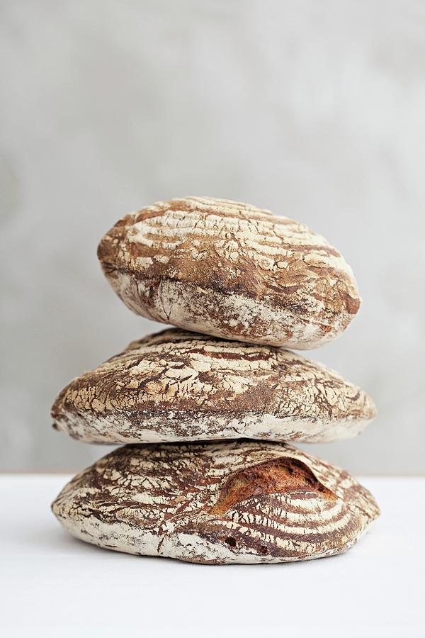 A Stack Of Three Loaves Of Sour Dough Bread Photograph by Steven Joyce