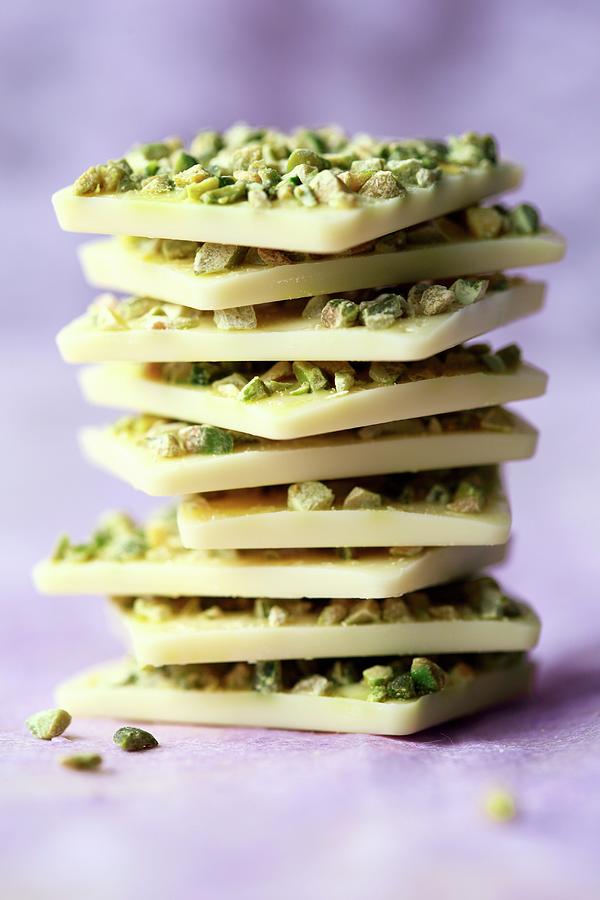 A Stack Of White Chocolate With Pistachios On A Purple Surface Photograph by Mona Binner Photographie
