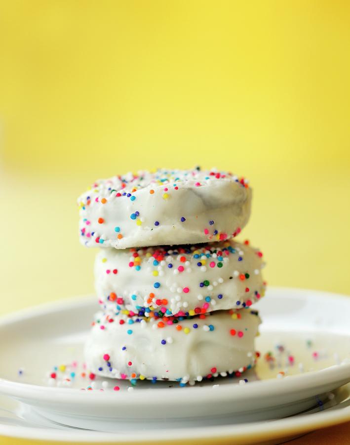 A Stack Of White Glazed Butter Biscuits And Colourful Sugar Sprinkles Photograph by Katharine Pollak