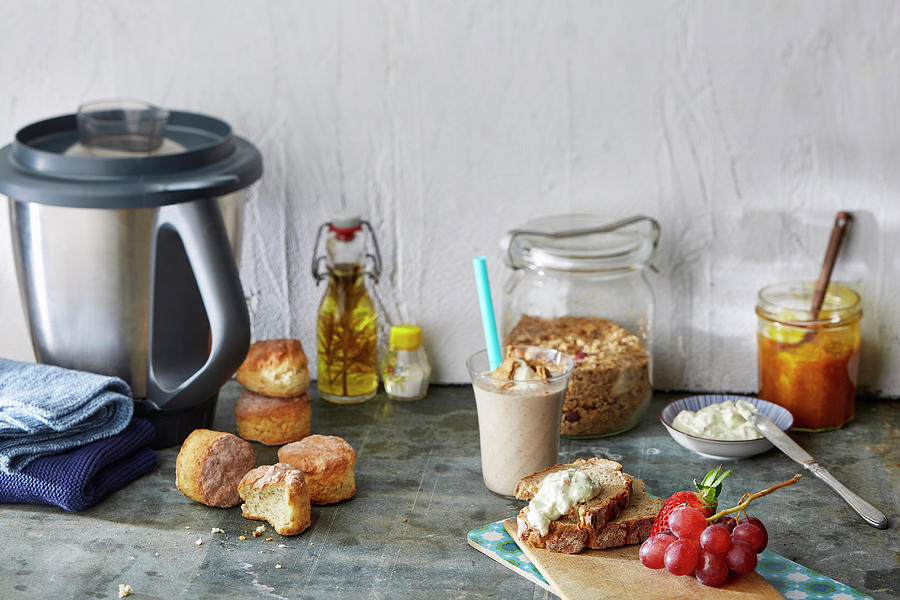 A Still Life With Bread Rolls, A Smoothie, Cereals, Bread, Spreads, Fruit, And Food Processor Photograph by Meike Bergmann