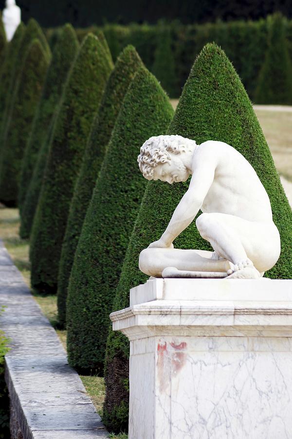 A Stone Figure On A Plinth In The Garden Of The Palace Of Versailles Photograph by Angelica Linnhoff