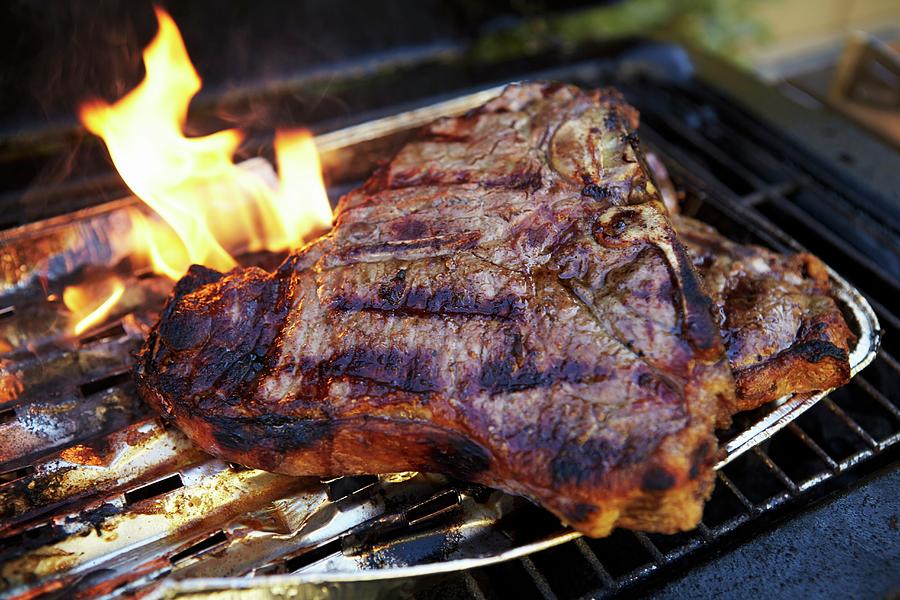 A T-bone Steak In An Aluminium Tray On A Barbecue Photograph by Jo Kirchherr
