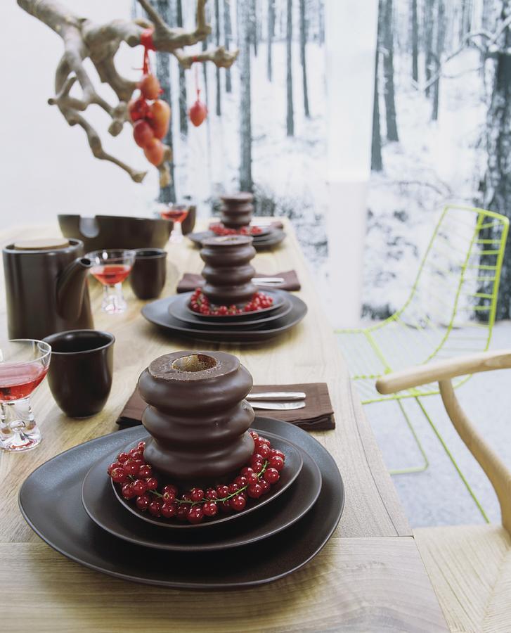 A Table Laid For Dessert - Baumkuchen german Layer Cakes With Trusses Of Redcurrants On A Set Of Dark Brown Ceramic Dishes Photograph by Matteo Manduzio