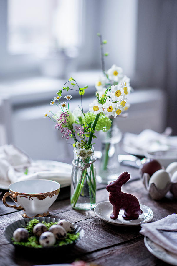 A Table Laid For Easter With Spring Flowers, Quail Eggs And A Chocolate Bunny Photograph by Carolin Strothe