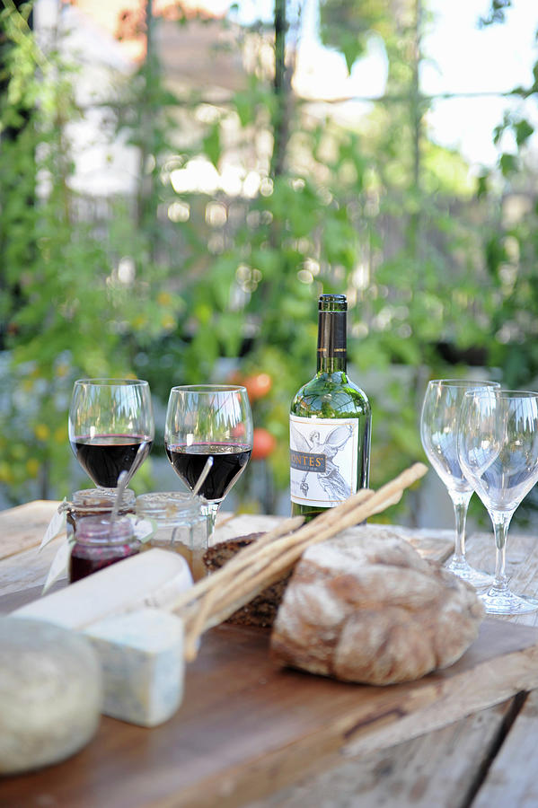 A Table Laid With Cheese, Bread And Wine In A Garden Photograph by Magdalena Bjrnsdotter