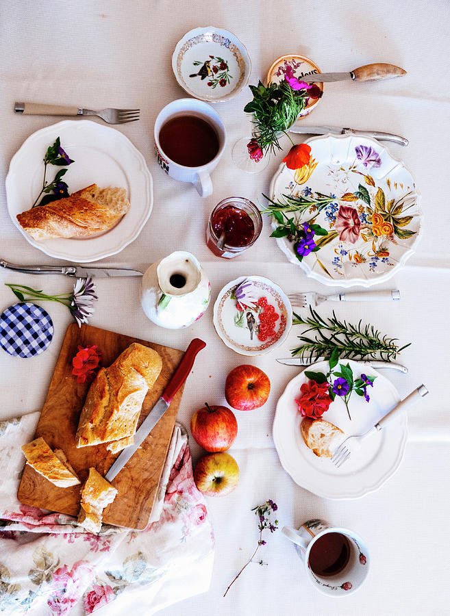 A Table With A White Cloth With French Bread, Marmelade, Apples And Tea Photograph by Lucie Beck