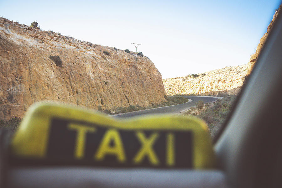 Transportation Photograph - A Taxi Drives On The Road Between Cliffs by Cavan Images
