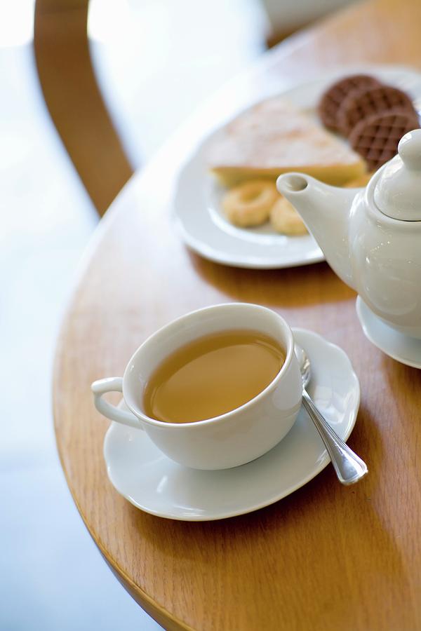 A Tea Still Life With A Cup Of Tea And A Plate Of Cakes And Biscuits Photograph by Imagerie