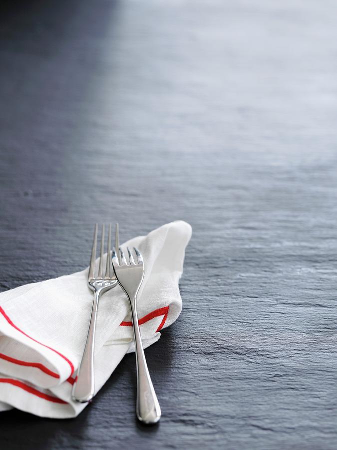 A Tea Towel And Two Forks On A Slate Surface Photograph by Gareth Morgans