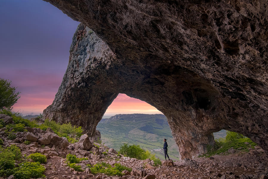 A Three Pillar Open Cave With A Woman Looking Over Her Shoulder Photograph by Vio Oprea