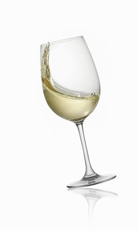 A Tilting Glass Of White Wine Photograph by Krger & Gross