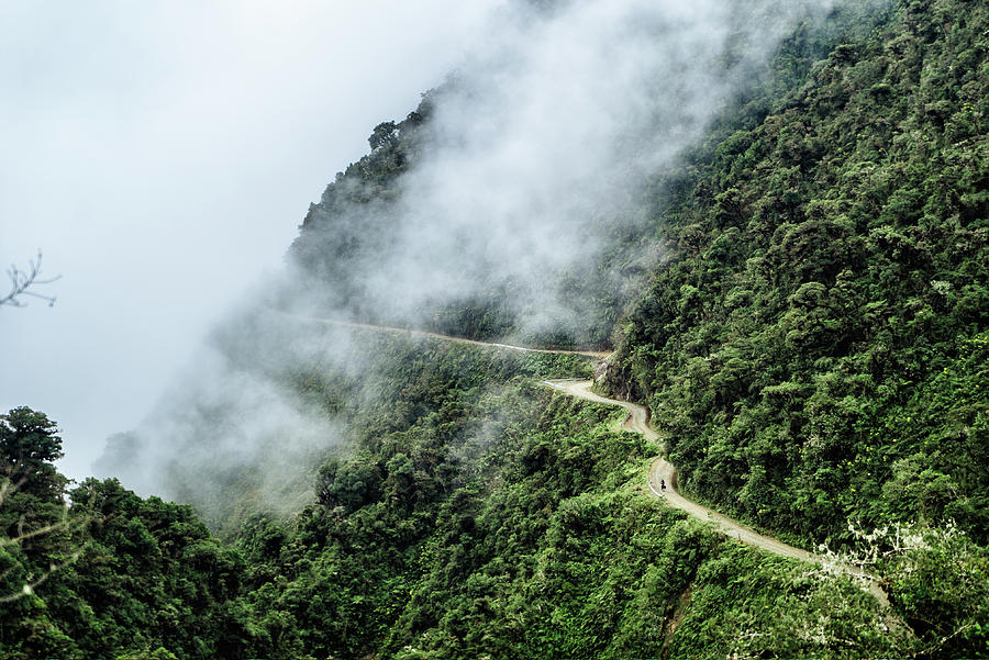 A tiny cyclist on the death road in Bolivia Photograph by Kamran Ali