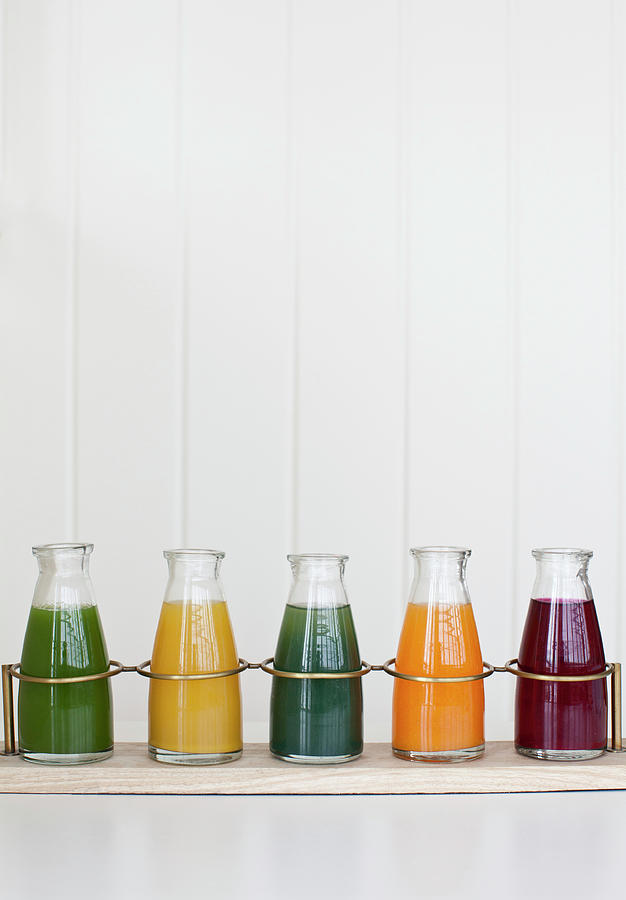 A Tray Holding Individual Jars Of Fresh Pressed Juices green Spinach, Lemon Ginger, Spirulina, Orange Carrot Turmeric, And Beet Photograph by Ryla Campbell