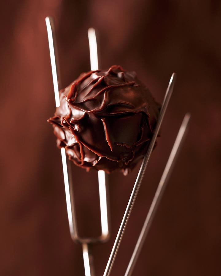 A Truffle Praline On A Praline Fork Photograph by Oliver Brachat