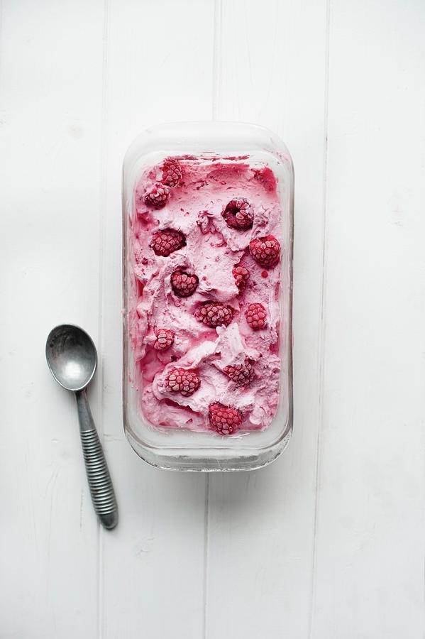 A Tub Of Frozen Raspberry Yogurt Next To An Ice Cream Scoop Photograph by Magdalena Hendey
