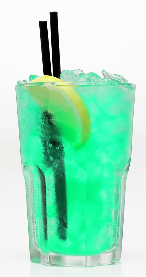 A Turquoise Cocktail With Crushed Ice Against A White Background Photograph by Ian Garlick