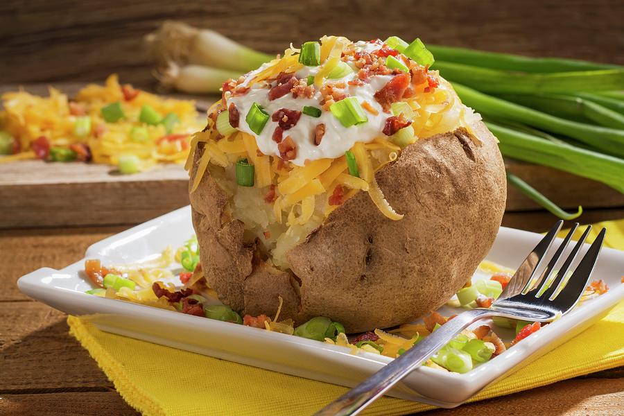 A Twice Baked Potato With Cheddar Cheese, Onions, Sour Cream And Bacon Photograph by Brian Enright