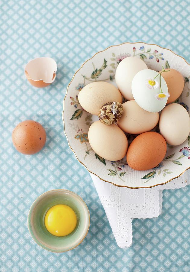 A Variety Of Eggs In A Bowl With A White And Yellow Flower; From Above; One Egg Cracked Open Photograph by Strokin, Yelena