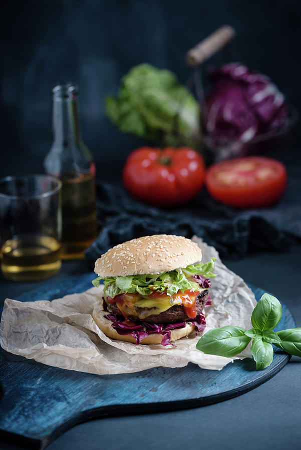 A Vegan Burger With A Vegetable Patty And Almond Cheese With Iced Tea And Vegetables In The Background Photograph by Kati Neudert