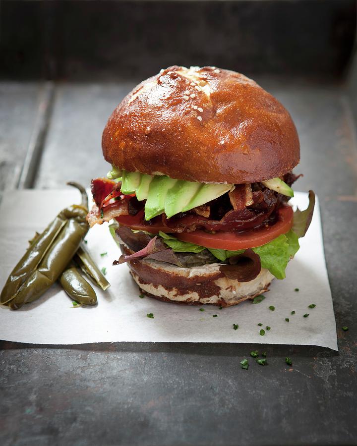 A Vegetable And Bacon Burger With Taco Sauce On A Lye Bread Roll Photograph by Great Stock!