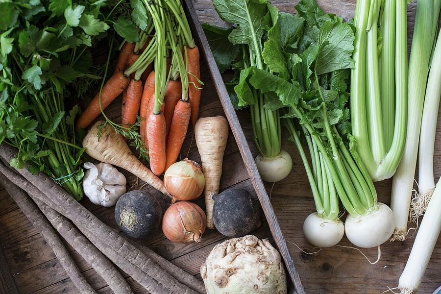 A Vegetable Crate With Root Vegetables, Onions And Parsley Photograph by Sabine Steffens