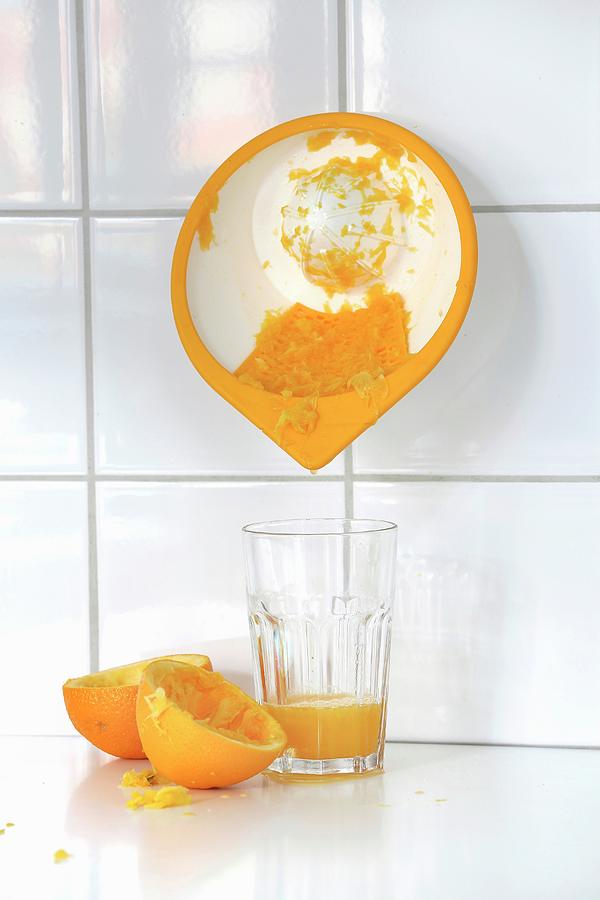 A Wall-mounted Citrus Press And A Glass Of Freshly Squeezed Orange Juice Photograph by Jalag / Michael Bernhardi