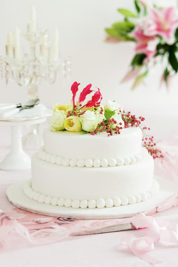 A Wedding Cake Decorated With Flowers Photograph by Andrew Young