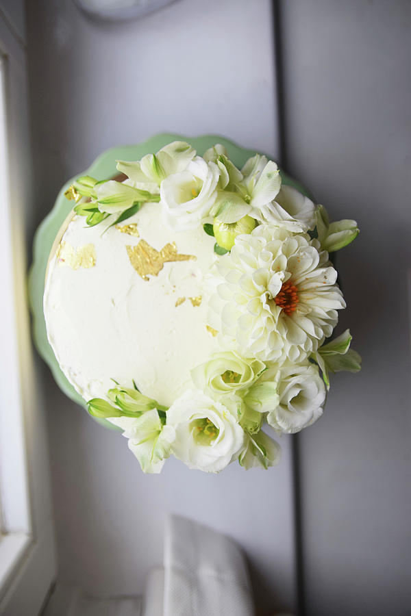 A Wedding Cake Decorated With Gold Leaf And White Flowers Photograph by So Schmeckt Liebe