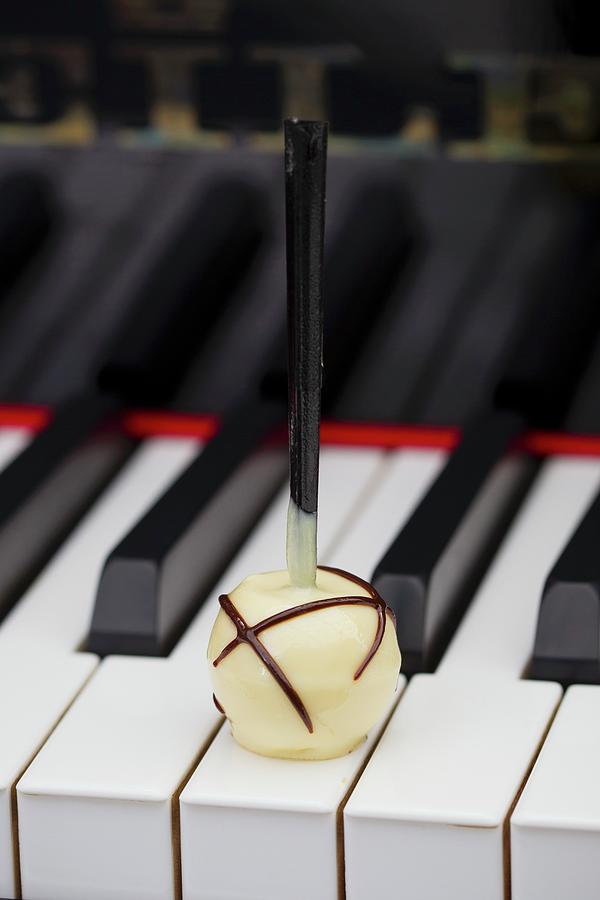 A White Chocolate Praline On The Keys Of A Piano Photograph by Esther Hildebrandt