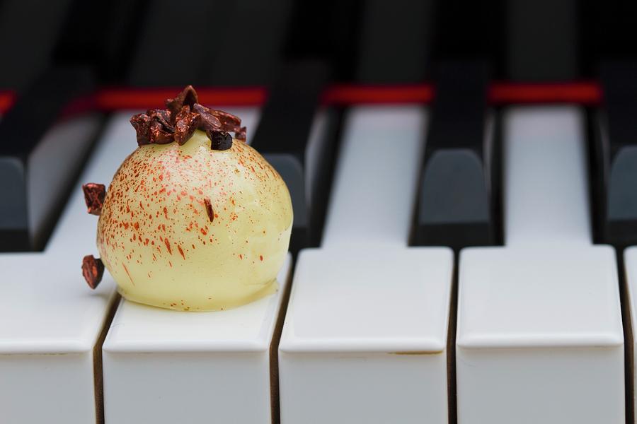 A White Praline On The Keys Of A Piano Photograph by Esther Hildebrandt