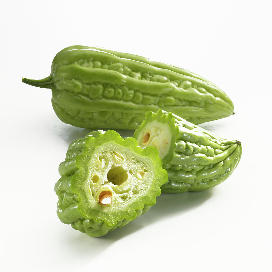 A Whole And A Halved Bitter Cucumber On A White Background Photograph by Linda Sonntag