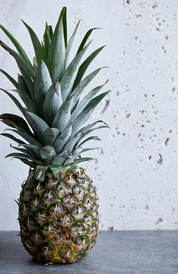 A Whole Pineapple Sitting On A Blue Countertop With A White Background Photograph by Ryla Campbell
